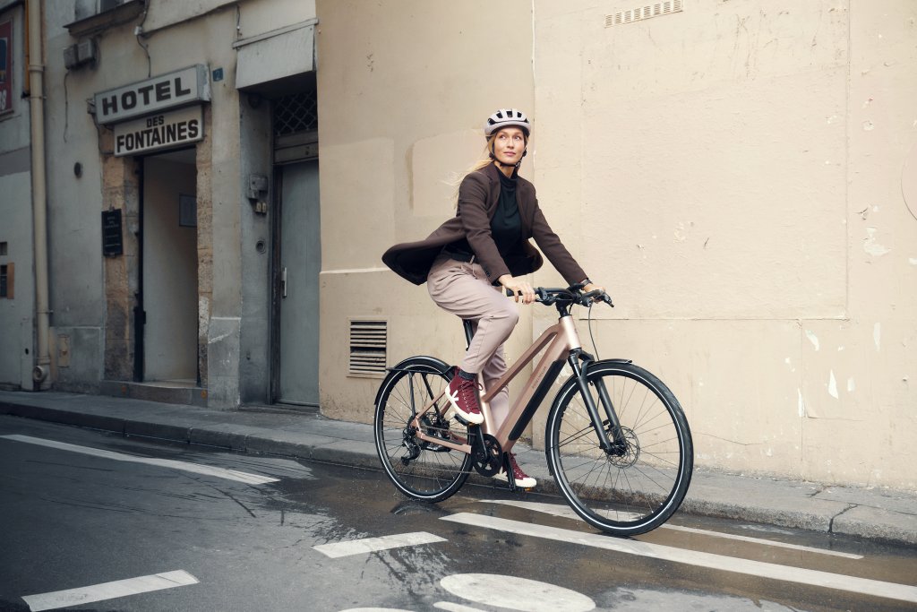 Eine Frau fährt auf einem Fahrrad durch eine Stadt.